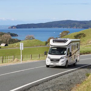 Britz Odyssey 4 Berth NZ Rear Island Bed Layout 01 Exterior Driving Coastal
